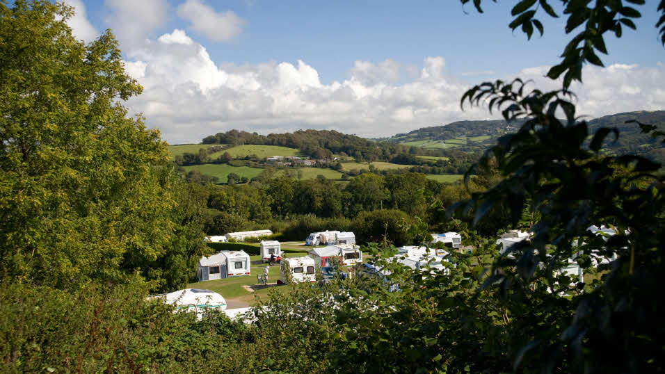 Wood Farm club site caravan pitches with hills in the background
